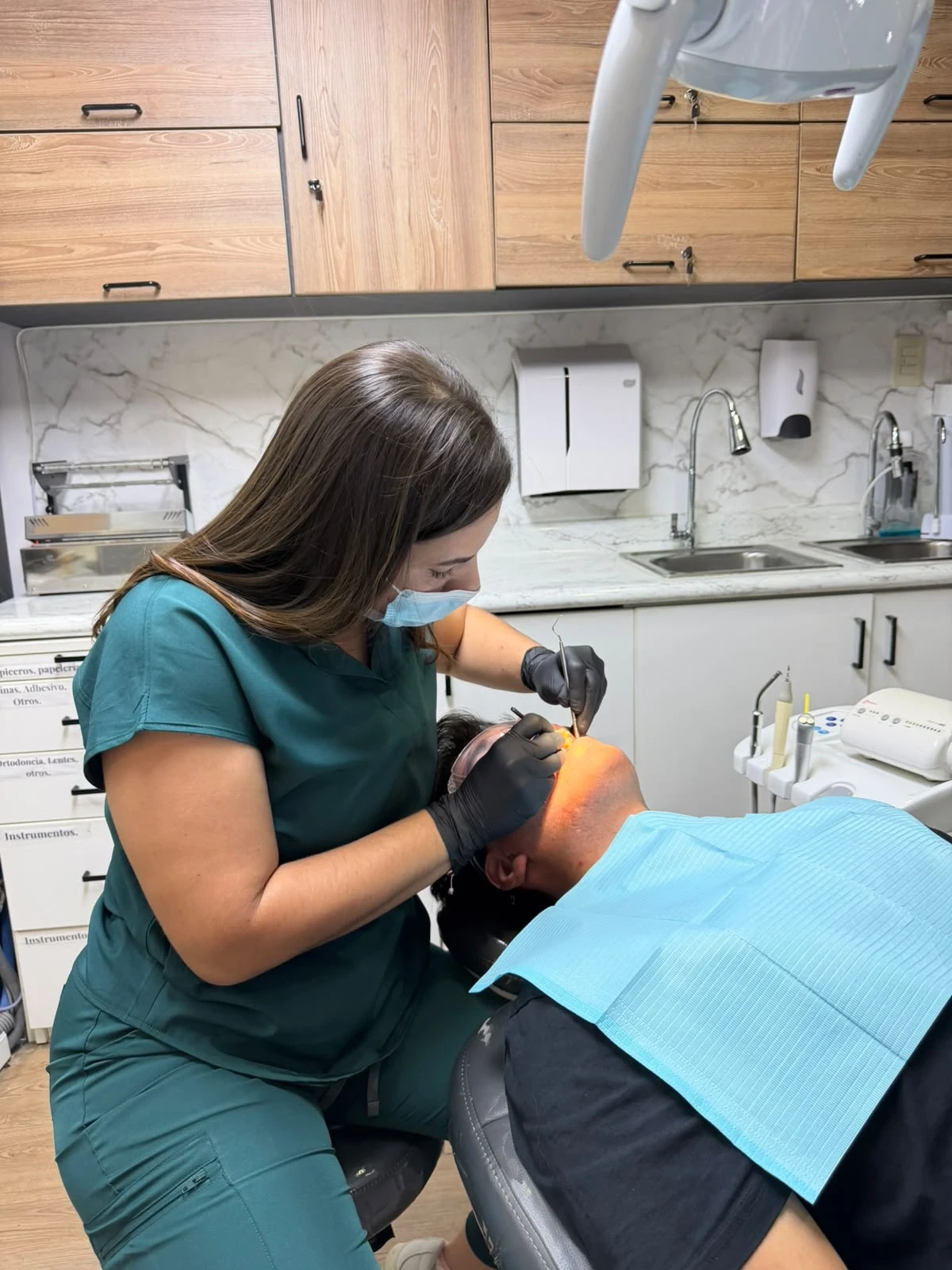 Odontóloga de CEDAR Perú revisando a un paciente en el sillón dental