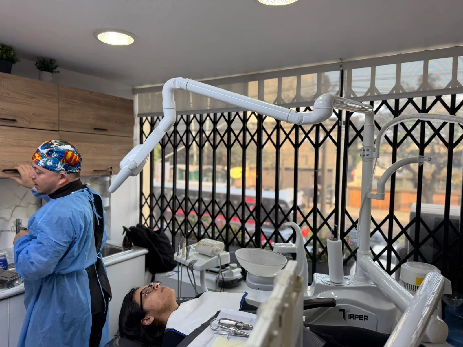 Odontólogo de CEDAR Perú preparando la atención de una paciente en el sillón dental